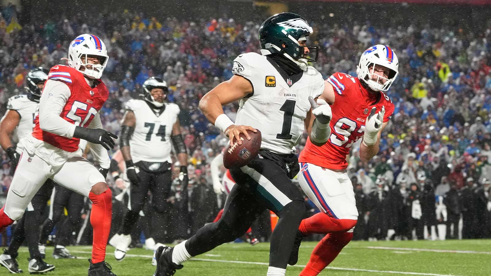 Philadelphia Eagles quarterback Jalen Hurts (1) scrambles against Buffalo Bills defensive ends Joey Bosa (97) and Greg Rousseau (50) during the third quarter at Highmark Stadium.