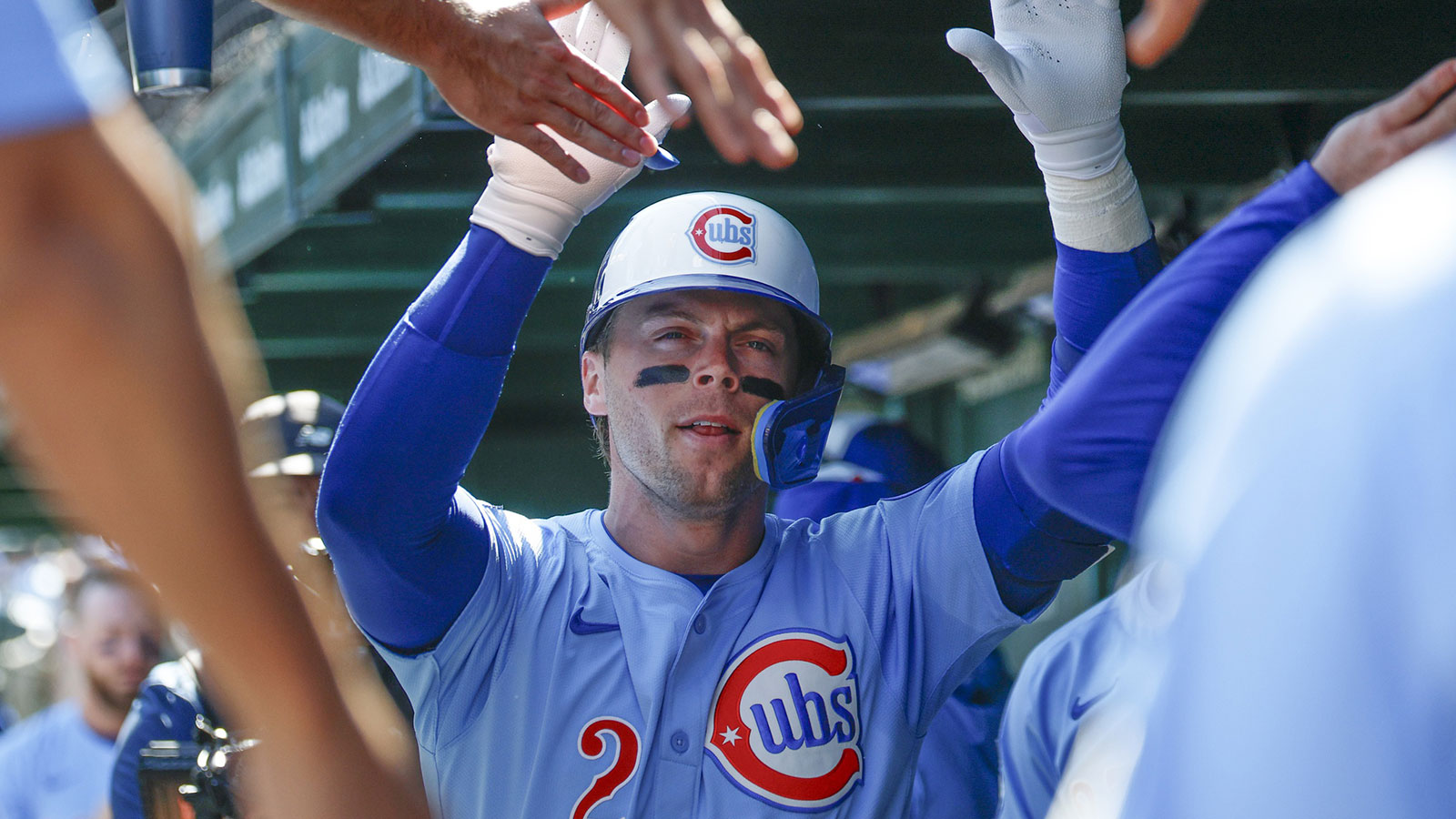 Chicago Cubs second baseman Nico Hoerner (2) celebrates with teammates in the dugout after hitting a solo home run against the St. Louis Cardinals during the first inning at Wrigley Field.