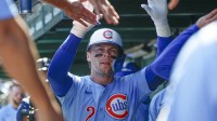 Chicago Cubs second baseman Nico Hoerner (2) celebrates with teammates in the dugout after hitting a solo home run against the St. Louis Cardinals during the first inning at Wrigley Field.