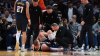 Denver Nuggets center Nikola Jokic (15) is looked at by trainers after an injury against the Miami Heat during the second quarter at Kaseya Center.
