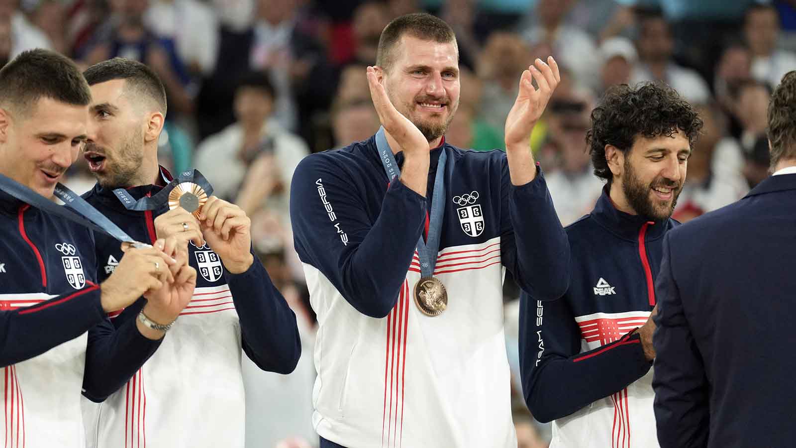 Serbia power forward Nikola Jokic (15) celebrates on the podium with teammates after winning the bronze medal in men's basketball during the Paris 2024 Olympic Summer Games at Accor Arena.