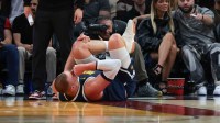 Denver Nuggets center Nikola Jokic (15) holds his knee after an injury against the Miami Heat during the second quarter at Kaseya Center.
