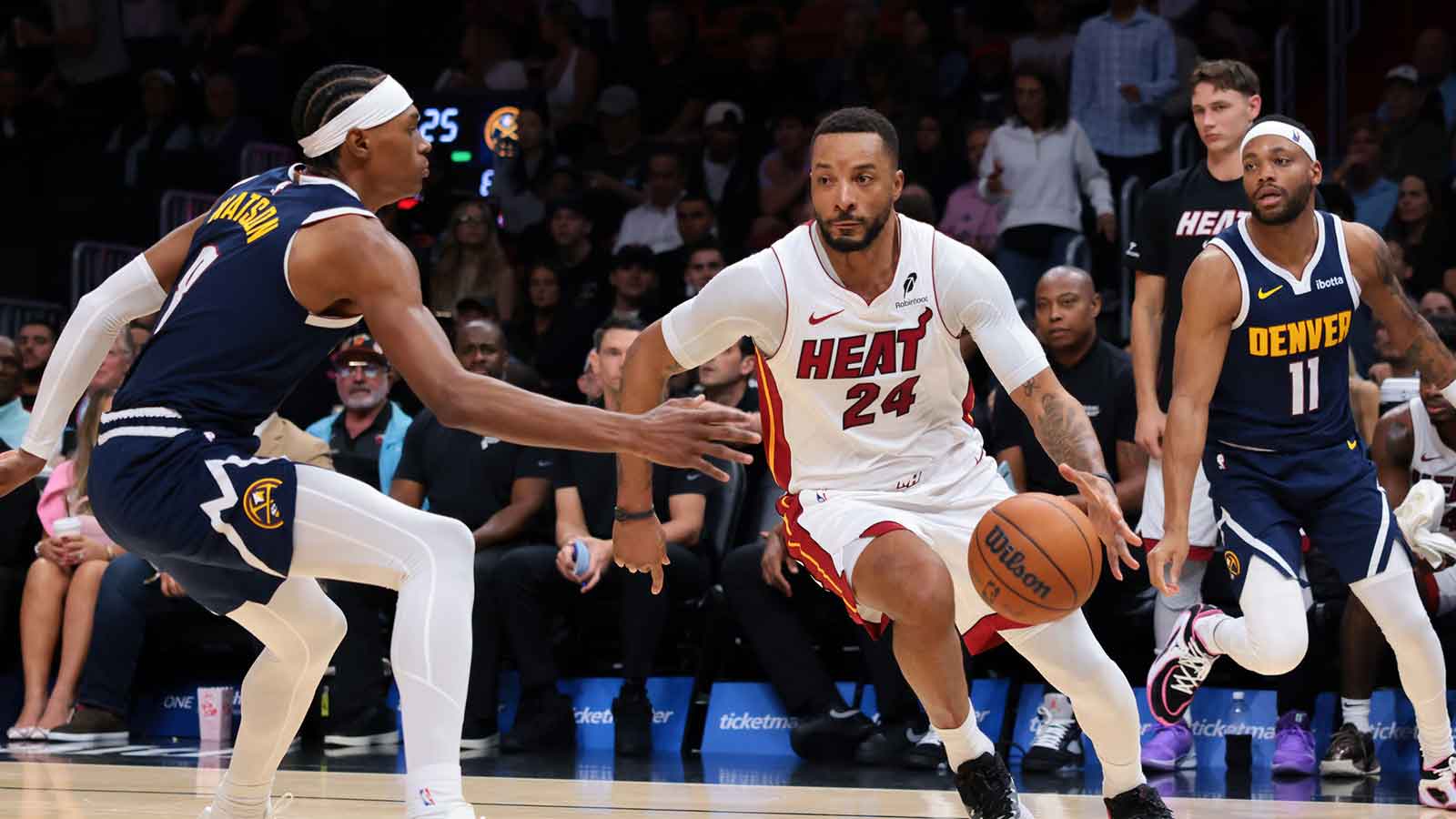Miami Heat guard Norman Powell (24) drives to the basket against Denver Nuggets guard Bruce Brown (11) and guard Peyton Watson (8) during the third quarter at Kaseya Center. 