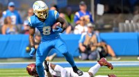 Los Angeles Chargers running back Omarion Hampton (8) breaks away from Washington Commanders linebacker Frankie Luvu (4) as he carries the ball at SoFi Stadium.