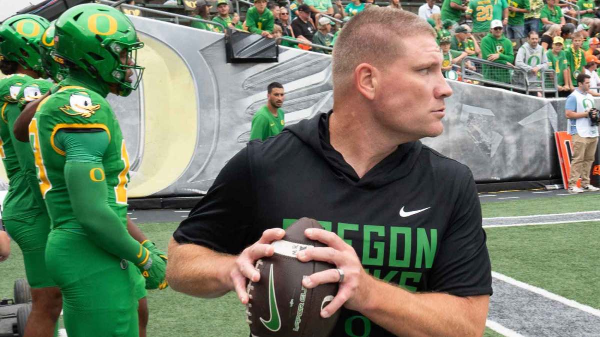 Oregon Defensive Coordinator Tosh Lupoi runs a warmup drill with his team before the game against Oklahoma State at Autzen.