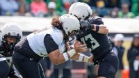 Fighting Ducks offensive lineman Lipe Moala, left, blocks Combat Ducks inside linebacker Brayden Platt as the Fighting Ducks face off against Mighty Oregon