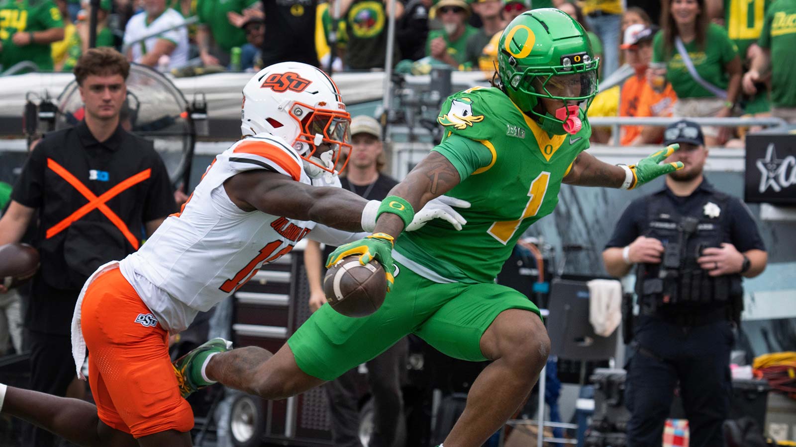 Oregon’s Dakorien Moore, right, flies over the goal line ahead of Oklahoma State’s David Kabongo for a second quarter touchdown at Autzen.