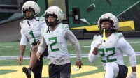 Oregonâs Dakorien Moore, left, Gary Bryant Jr. and Jay Harris work out during practice at Autzen Stadium in Eugene Dec. 14, 2025 before the first-round CFP game against James Madison.