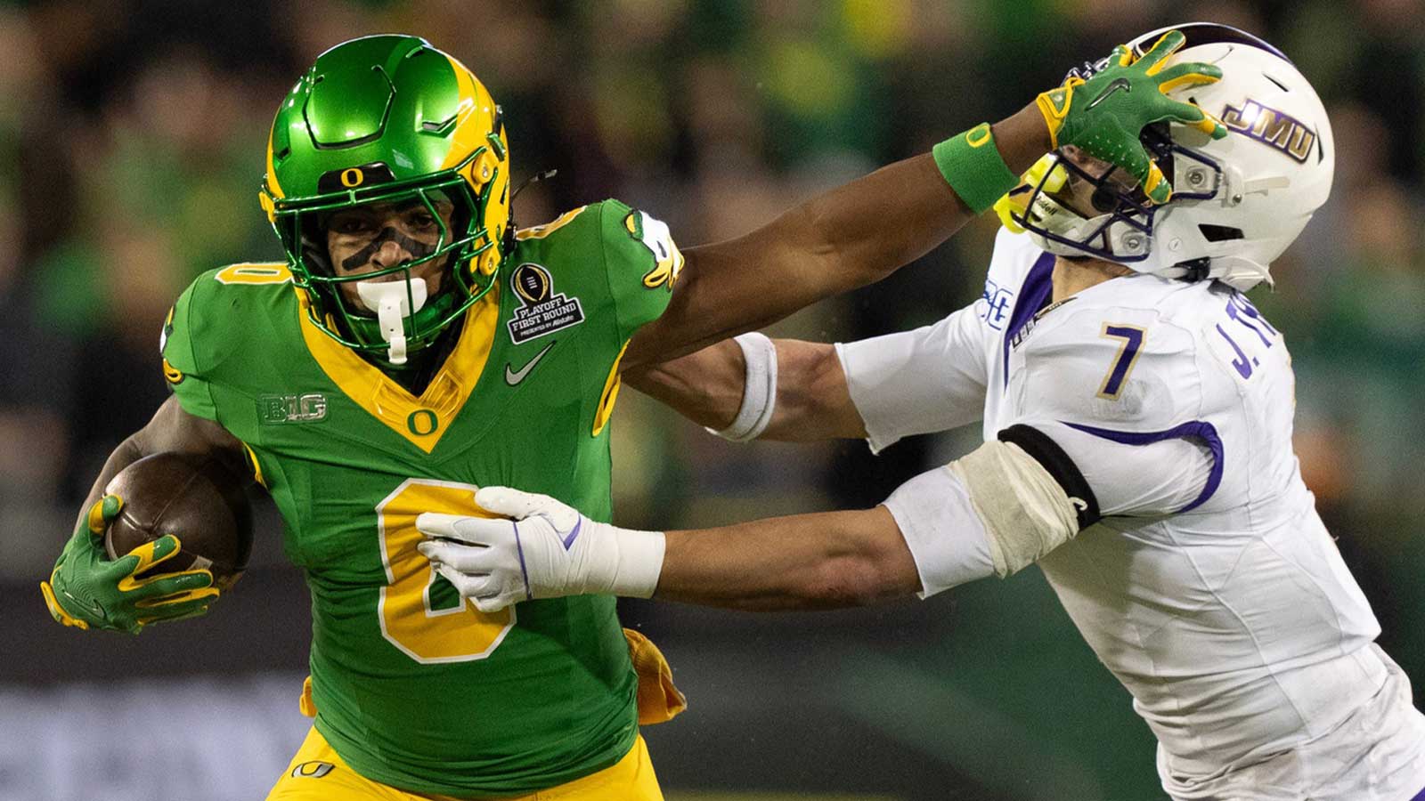 Oregon’s Jordon Davison, left, stiff arms James Madison’s Jacob Thomas for a gain during the second quarter Autzen Stadium in Eugene Dec. 20, 2025.