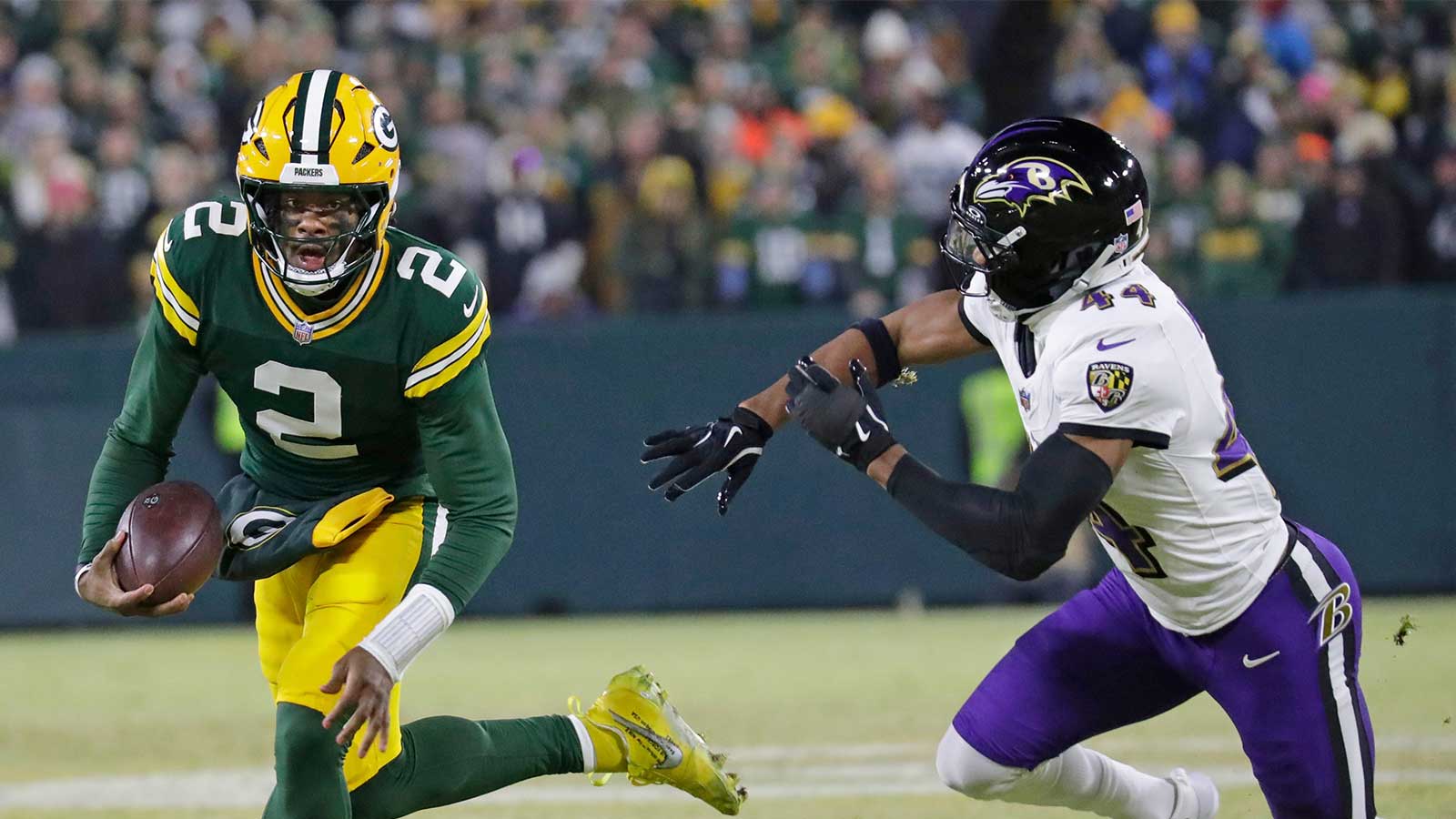 Green Bay, Wisconsin, USA; Green Bay Packers quarterback Malik Willis (2) breaks away from Baltimore Ravens cornerback Marlon Humphrey (44) to score a touchdown in the second quarter at Lambeau Field in Green Bay, Wisconsin.