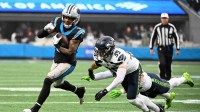 Carolina Panthers running back Rico Dowdle (5) runs the ball against Seattle Seahawks safety Ty Okada (39) and linebacker Drake Thomas (42) (obscured) during the second quarter at Bank of America Stadium.