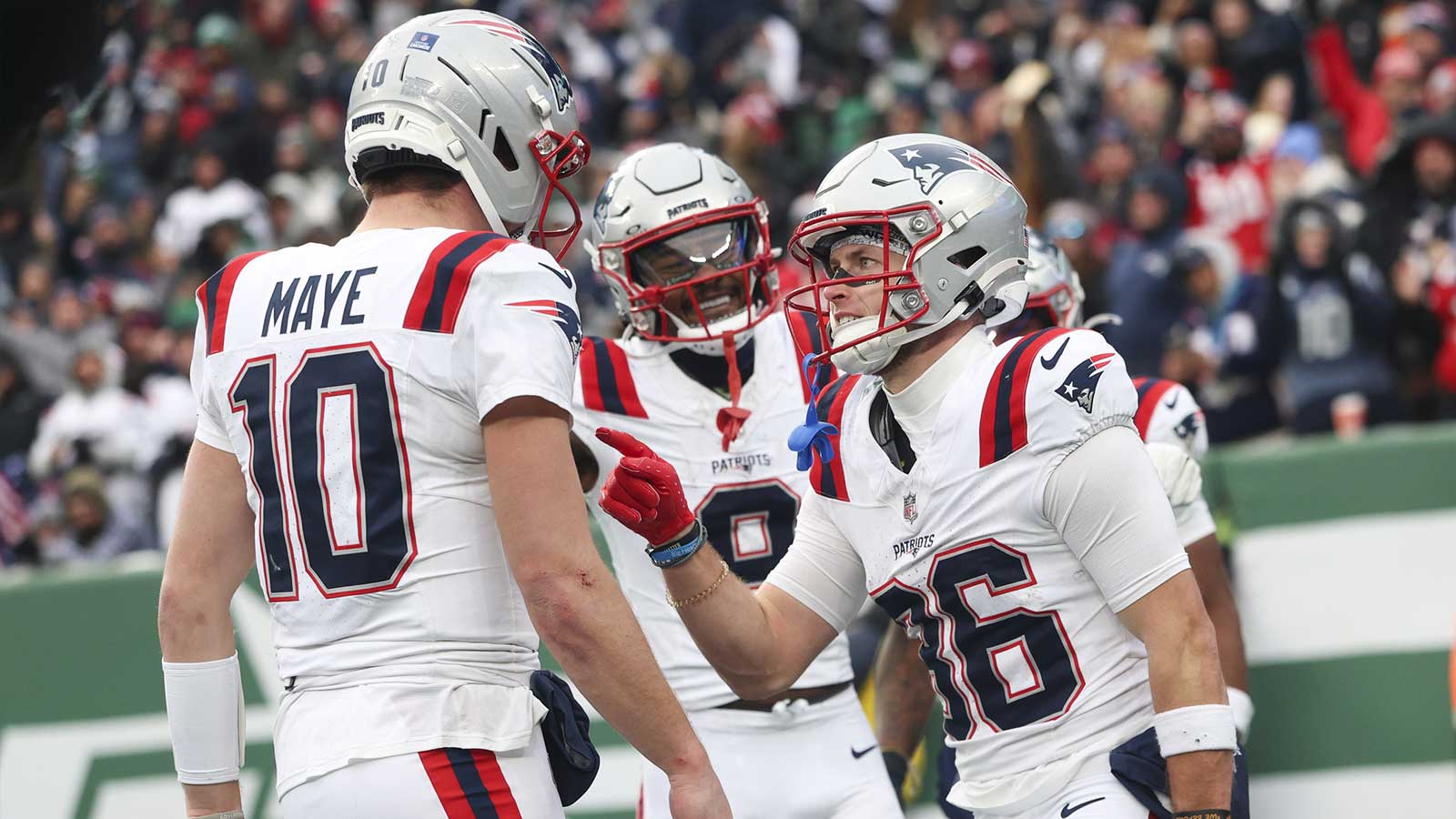 New England Patriots wide receiver Efton Chism III (86) celebrates his touchdown catch against the New York Jets with New England Patriots quarterback Drake Maye (10) during the second half of the game at MetLife Stadium.