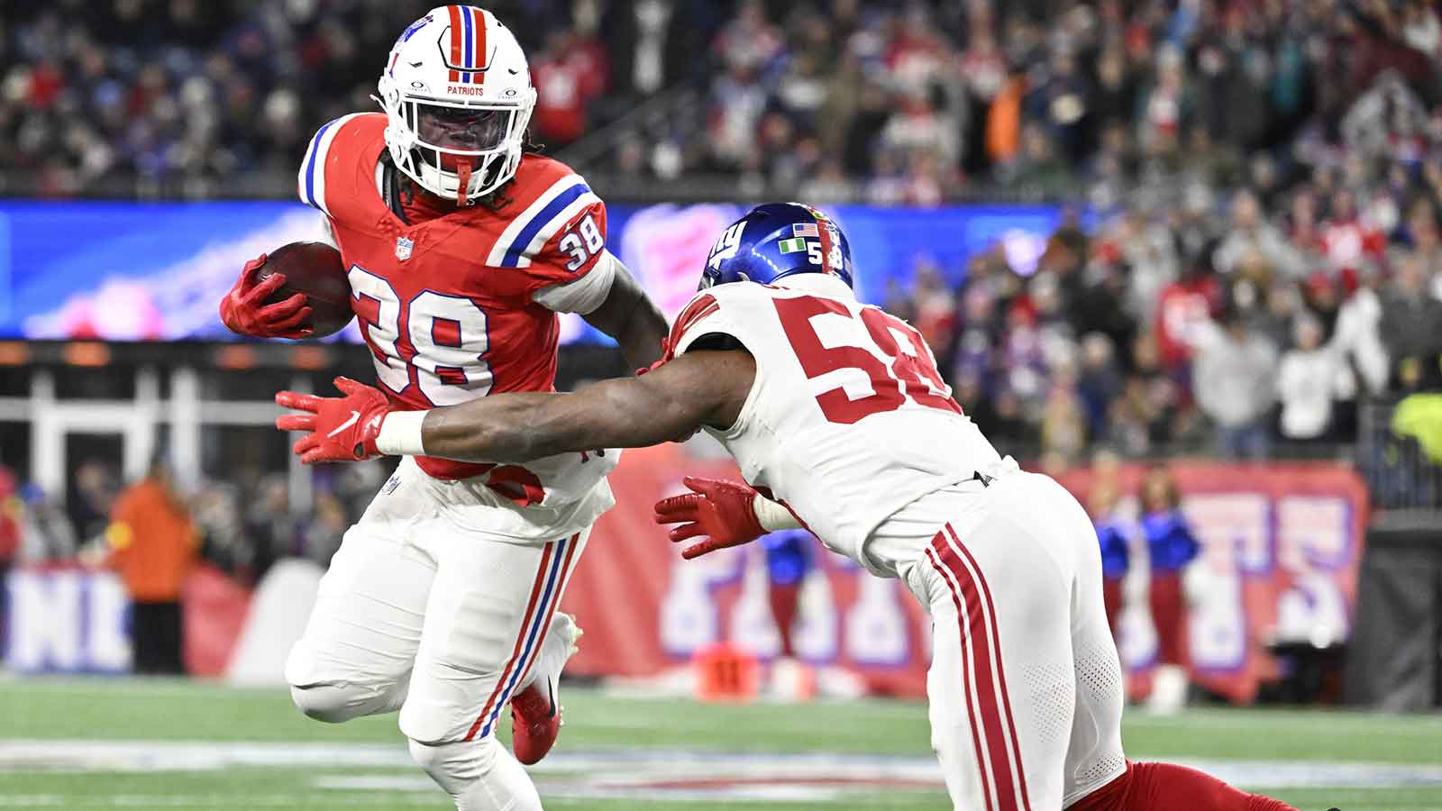 New England Patriots running back Rhamondre Stevenson (38) runs the ball against New York Giants linebacker Bobby Okereke (58) during the third quarter at Gillette Stadium.