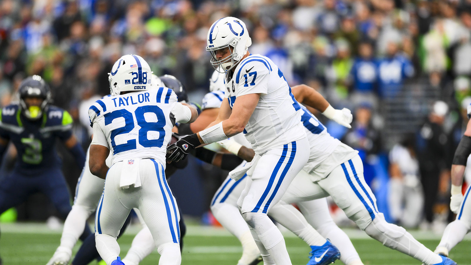 Indianapolis Colts quarterback Philip Rivers (17) hands the ball of to running back Jonathan Taylor (28) during the second quarter against the Seattle Seahawks at Lumen Field.