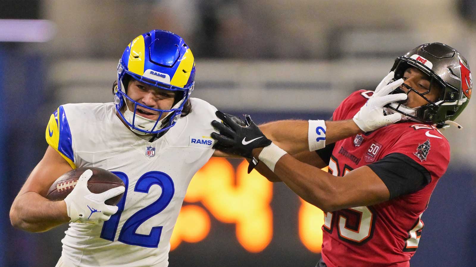 Los Angeles Rams wide receiver Puka Nacua (12) stiff arms Tampa Bay Buccaneers cornerback Jacob Parrish (25) as he runs for a first down at SoFi Stadium. 
