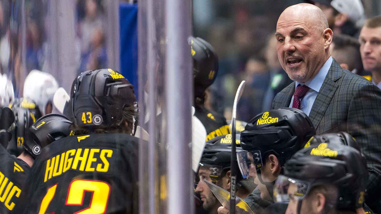 Vancouver Canucks head coach Rick Tocchet talks with defenseman Quinn Hughes (43) on the bench against the Columbus Blue Jackets during the third period at Rogers Arena. 