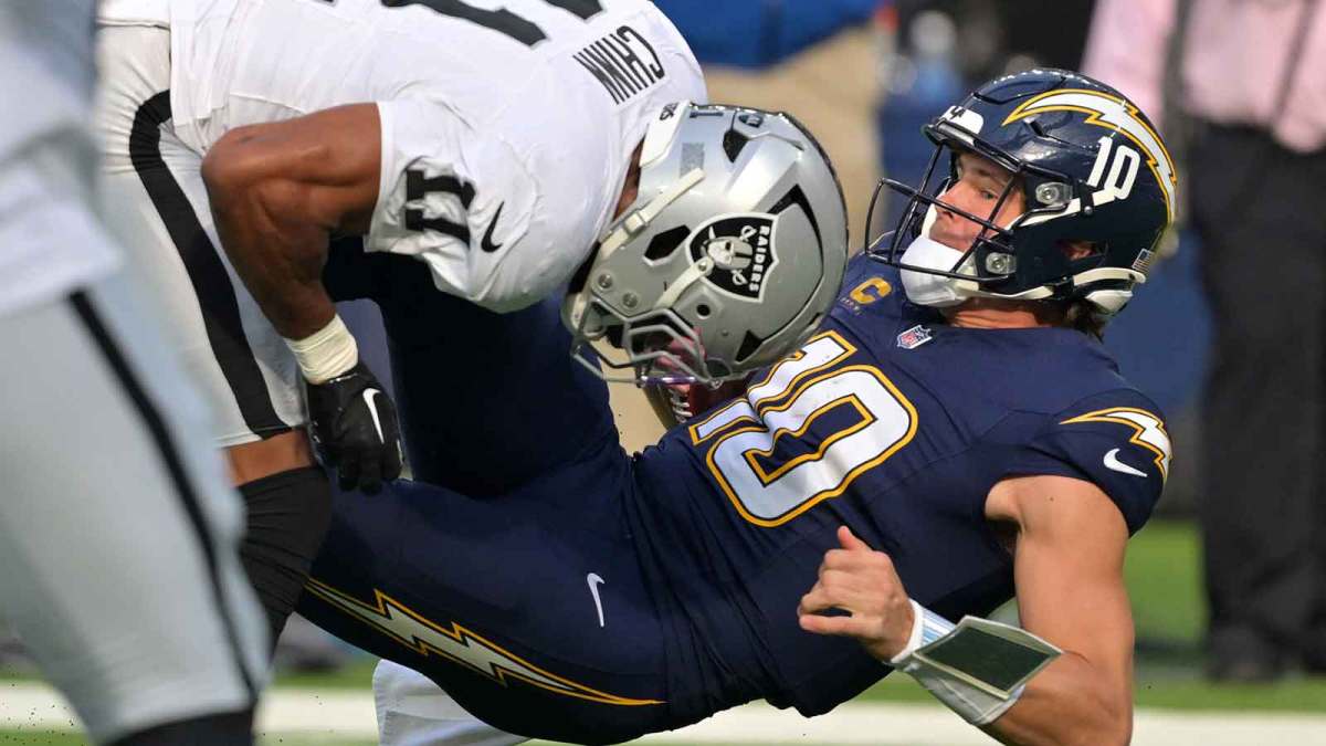 Las Vegas Raiders safety Jeremy Chinn (11) tackles Los Angeles Chargers quarterback Justin Herbert (10) during the first half at SoFi Stadium.
