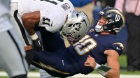 Las Vegas Raiders safety Jeremy Chinn (11) tackles Los Angeles Chargers quarterback Justin Herbert (10) during the first half at SoFi Stadium.