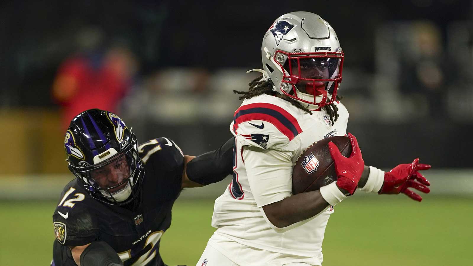 New England Patriots running back Rhamondre Stevenson (38) runs the ball against Baltimore Ravens safety Alohi Gilman (12) during the second half of the game at M&T Bank Stadium.
