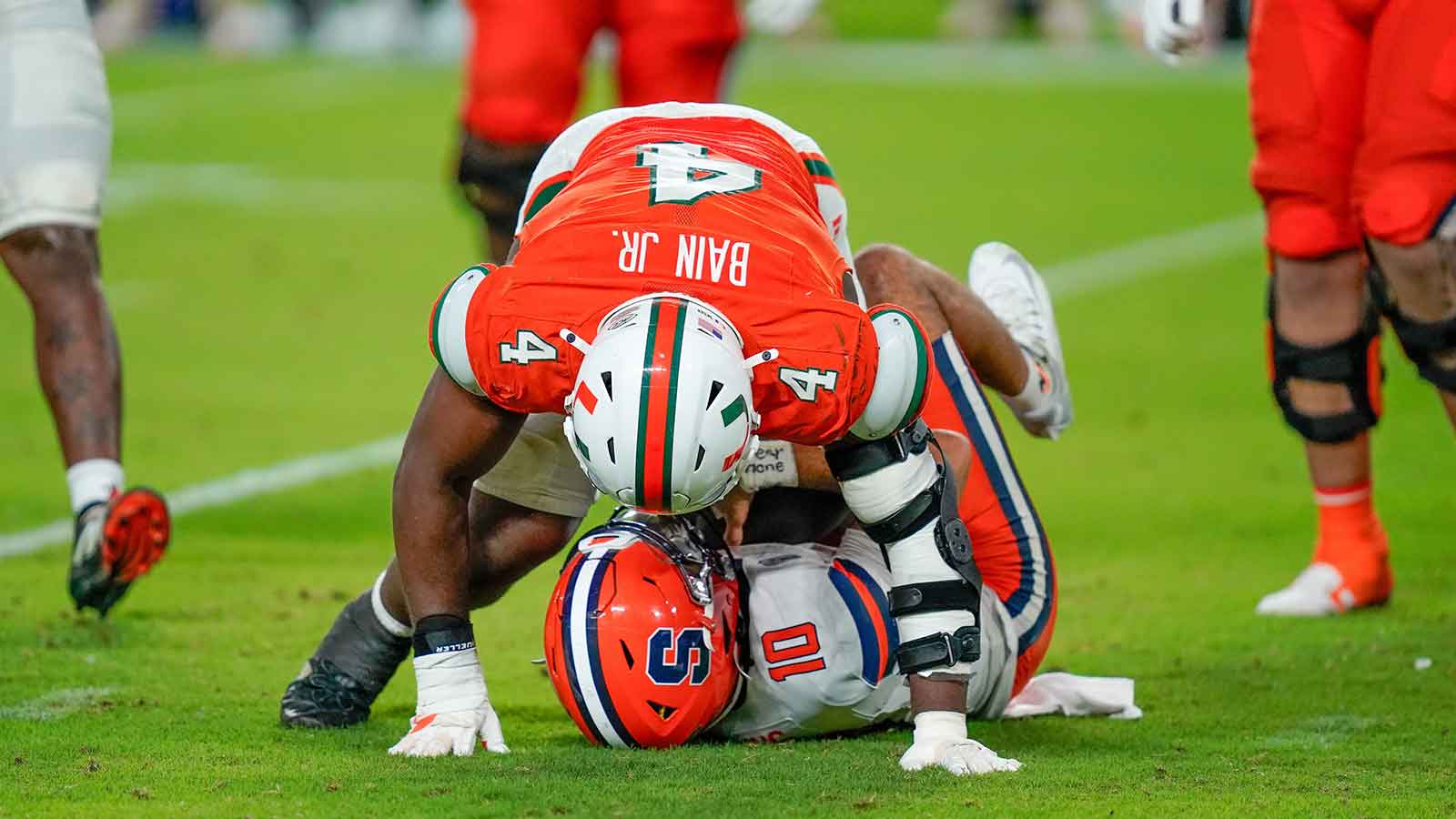 Syracuse Orange quarterback Rickie Collins (10) is sacked by Miami Hurricanes defensive lineman Rueben Bain Jr. (4) during the fourth quarter at Hard Rock Stadium.