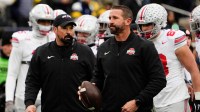 Ohio State Buckeyes offensive coordinator Brian Hartline and head coach Ryan Day leads warm ups during the NCAA football game against the Michigan Wolverines at Michigan Stadium in Ann Arbor, Mich. on Nov. 29, 2025. Ohio State won 27-9.