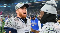 Seattle Seahawks quarterback Sam Darnold (14) and quarterback Jalen Milroe (6) celebrate after defeating the Los Angeles Rams in overtime at Lumen Field.