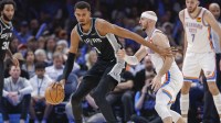 San Antonio Spurs forward Victor Wembanyama (1) moves the ball across the court against Oklahoma City Thunder guard Alex Caruso (9) during the second half at Paycom Center.