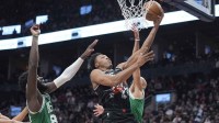 Toronto Raptors guard Scottie Barnes (4) goes up to make a basket against Boston Celtics center Neemias Queta (88) and guard Derrick White (9) during the second half at Scotiabank Arena.