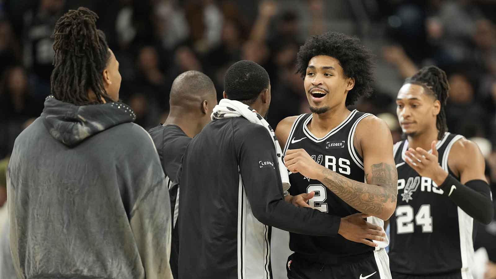 Spurs guard Dylan Harper (2) is congratulated by teammates after scoring before a timeout in the second half against the Memphis Grizzlies at Frost Bank Center