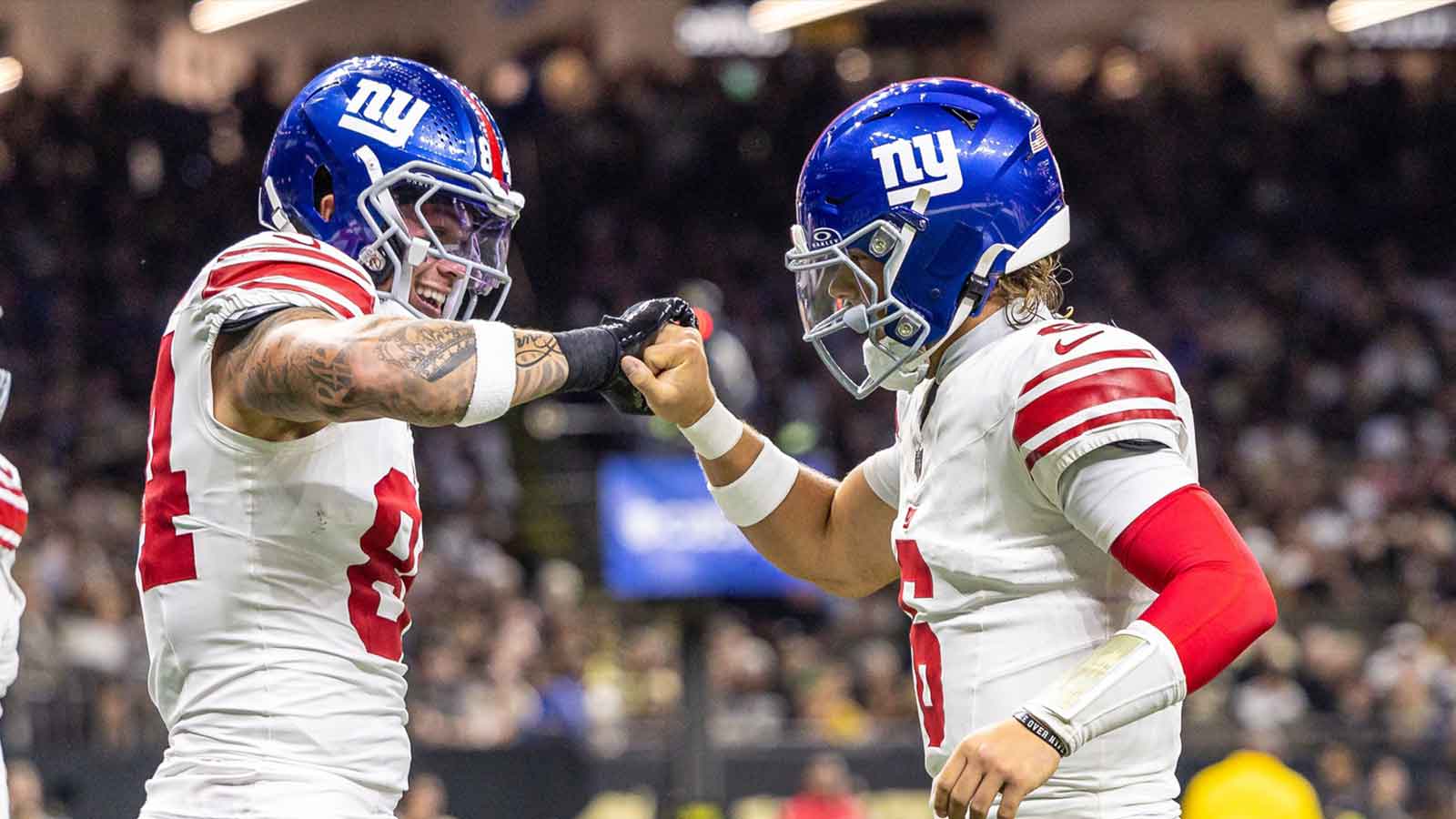 New York Giants tight end Theo Johnson (84) and quarterback Jaxson Dart (6) react to a touchdown against New Orleans Saints during the first half at Caesars Superdome.