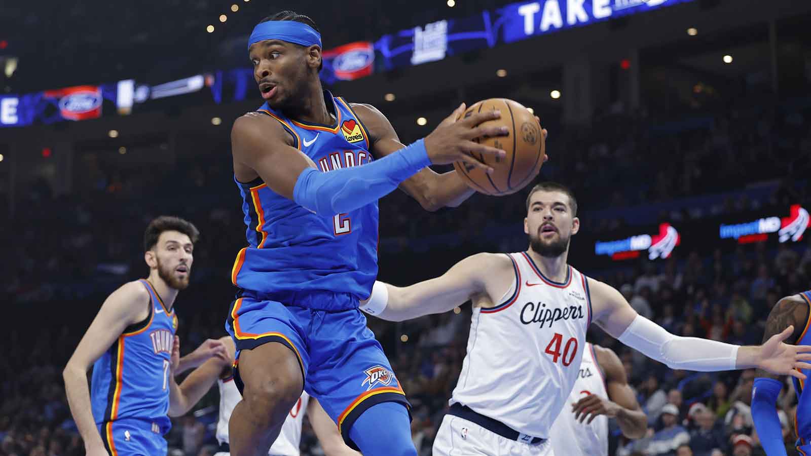 Thunder guard Shai Gilgeous-Alexander (2) grabs a rebound after a shot by the Los Angeles Clippers during the first quarter at Paycom Center