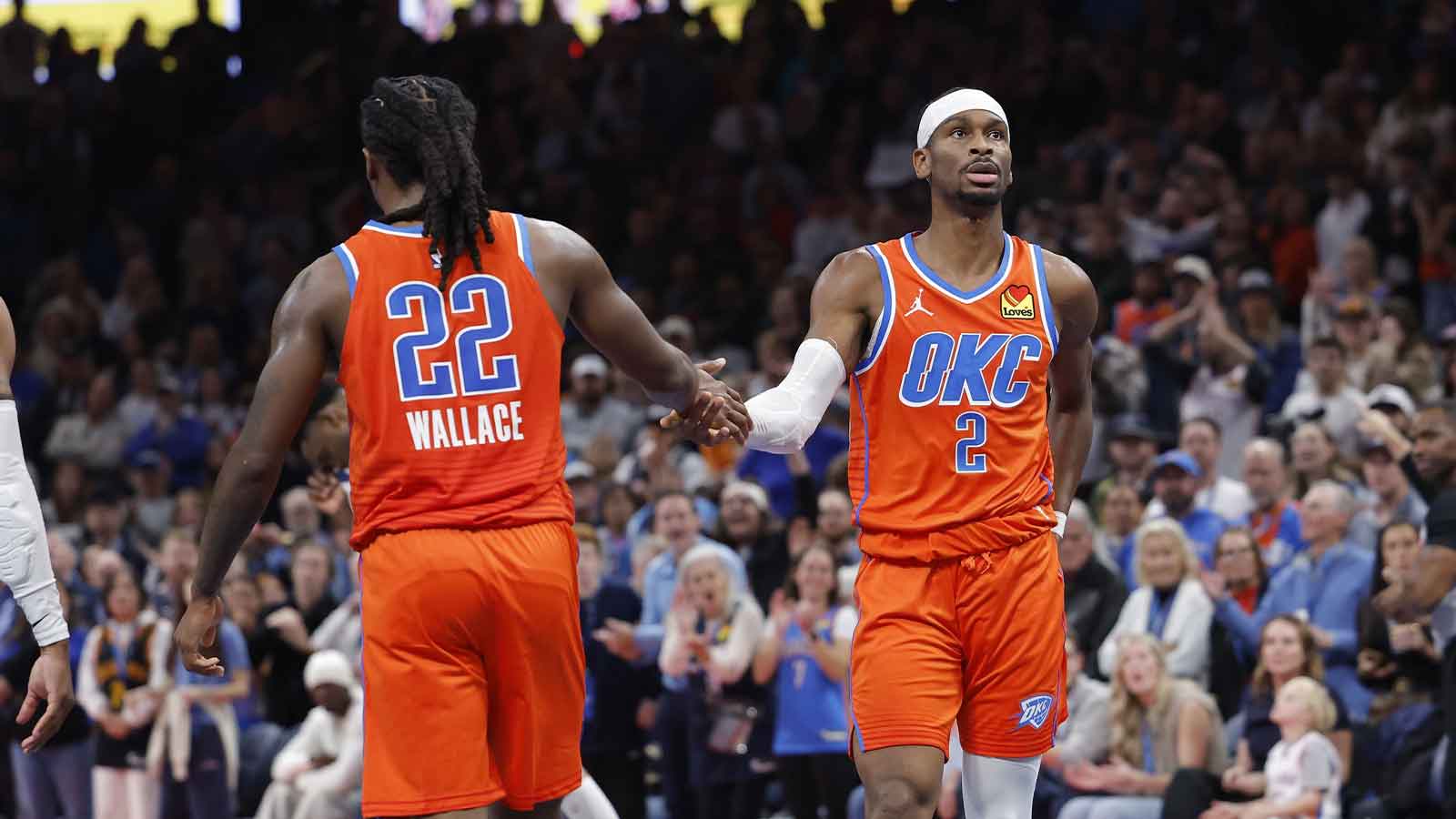Thunder guard Shai Gilgeous-Alexander (2) high fives Oklahoma City Thunder guard Cason Wallace (22) after a play against the Minnesota Timberwolves during the second half at Paycom Center