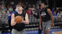 Thunder forward Brooks Barnhizer (23) shoots as guard Chris Youngblood (3) watches during pregame warm ups against the Charlotte Hornets at Spectrum Center with Thunder's Shai Gilgeous-Alexander and Jalen Williams in the background