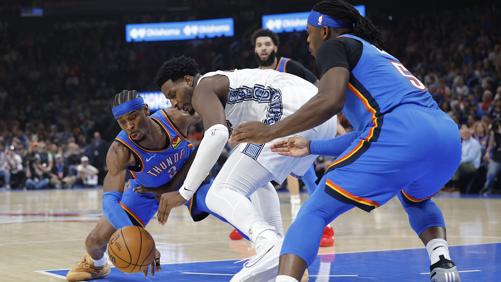Grizzlies forward Jaren Jackson Jr. (8) fights for a loose ball between Oklahoma City Thunder guard Shai Gilgeous-Alexander (2) and guard Luguentz Dort (5) during the second quarter at Paycom Center
