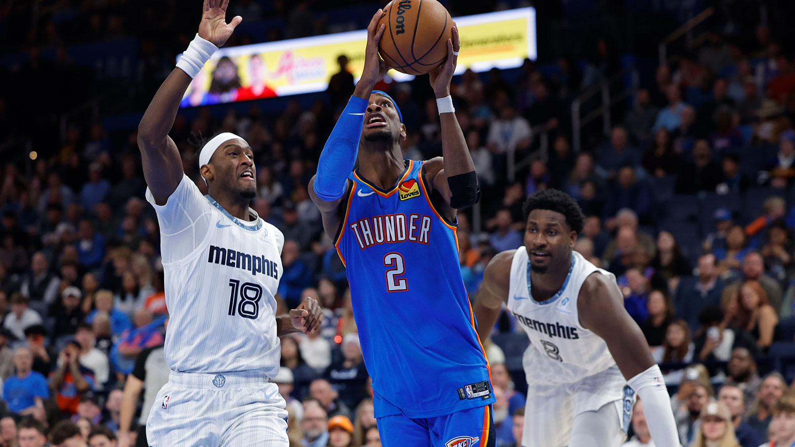 Thunder guard Shai Gilgeous-Alexander (2) goes to the basket beside Memphis Grizzlies forward Olivier-Maxence Prosper (18) during the second half at Paycom Center