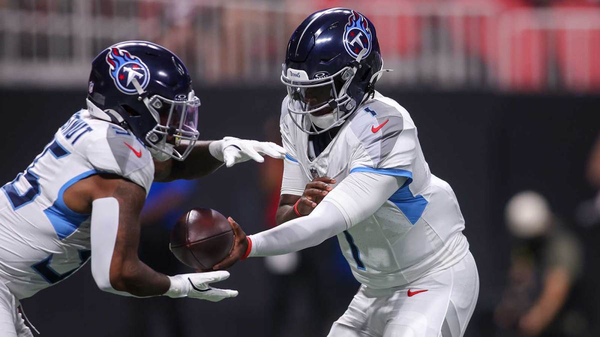 Tennessee Titans quarterback Cameron Ward (1) hands the ball off to running back Julius Chestnut (36) against the Atlanta Falcons in the first quarter at Mercedes-Benz Stadium.