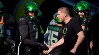 Oregon defensive coordinator Tosh Lupoi, right, greets Oregon defensive back Ify Obidegwu before the game as the Oregon Ducks host the USC Trojans on Nov. 22, 2025, at Autzen Stadium in Eugene, Oregon.