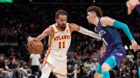 Atlanta Hawks guard Trae Young (11) protects the ball against Charlotte Hornets guard LaMelo Ball (1) during the fourth quarter at State Farm Arena.