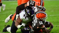 Cleveland Browns quarterback Shedeur Sanders (12) is sacked by Baltimore Ravens cornerback Keyon Martin (38) and defensive tackle Travis Jones (98) during the third quarter at Huntington Bank Field.