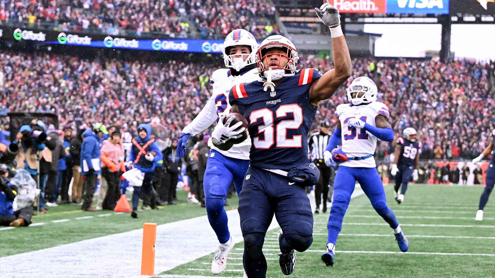 New England Patriots running back Treveyon Henderson (32) scores a touchdown against the Buffalo Bills during the first half at Gillette Stadium. 