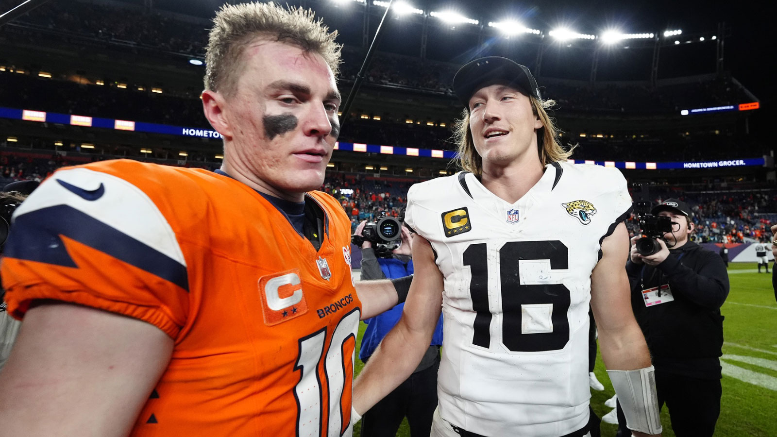 Denver Broncos quarterback Bo Nix (10) and Jacksonville Jaguars quarterback Trevor Lawrence (16) meet after the game at Empower Field at Mile High. 