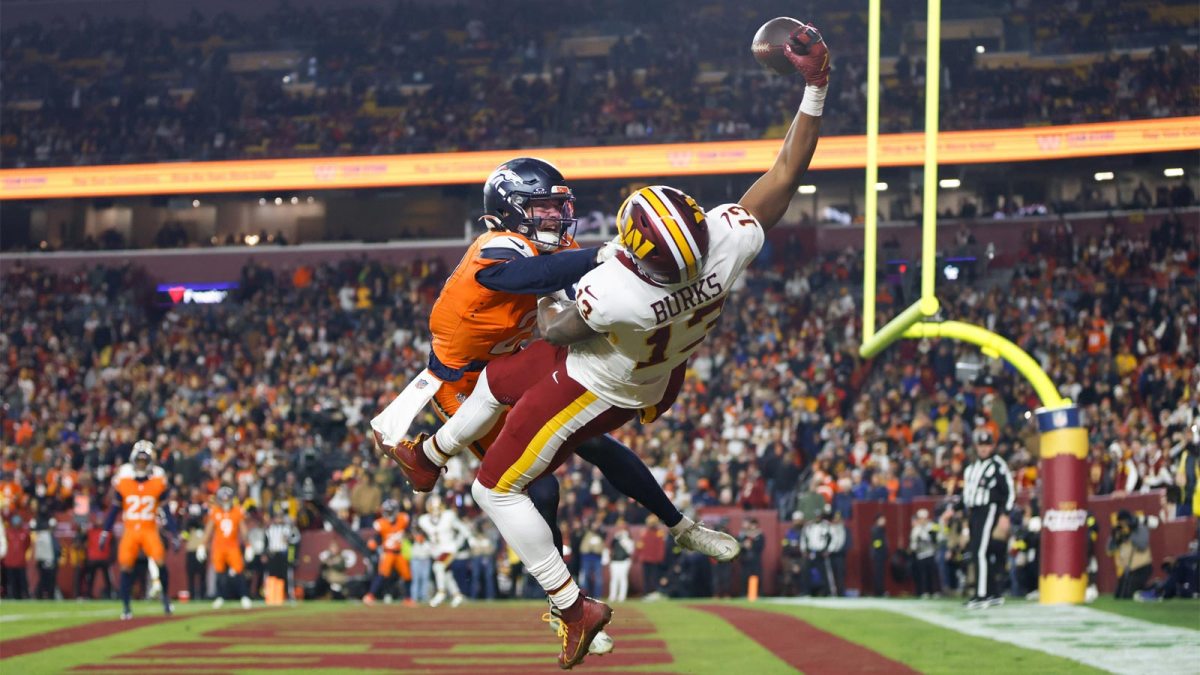 Washington Commanders wide receiver Treylon Burks (13) makes a catch for a touchdown defended by Denver Broncos cornerback Riley Moss (21) in the third quarter of the game at Northwest Stadium.