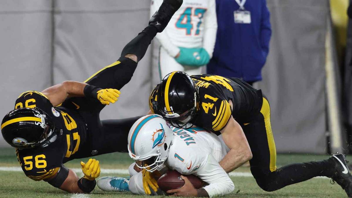 Miami Dolphins quarterback Tua Tagovailoa (1) is sacked by Pittsburgh Steelers linebacker Payton Wilson (41) and linebacker Alex Highsmith (56) in the third quarter at Acrisure Stadium.