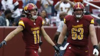 Washington Commanders wide receiver Luke McCaffrey (11) celebrates its Commanders center Tyler Biadasz (63) after scoring a touchdown against the Las Vegas Raiders during the fourth quarter at Northwest Stadium.