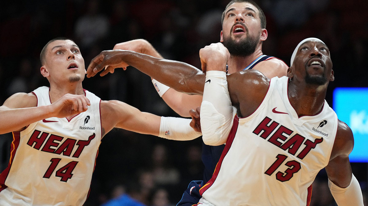 Miami Heat center Bam Adebayo (13) and Los Angeles Clippers center Ivica Zubac (40) battle for possession as guard Tyler Herro (14) follows on the play during the first half at Kaseya Center.