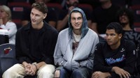 Miami Heat guard Pelle Larsson, left, guard Tyler Herro, center, and guard Dru Smith, right, sit on the bench against the Sacramento Kings during the second half at Kaseya Center.