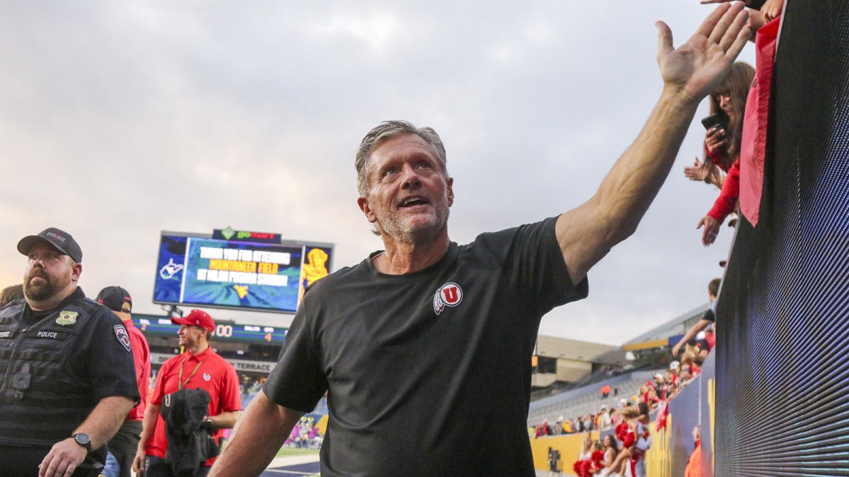 Utah Utes head coach Kyle Whittingham celebrates with fans after defeating the West Virginia Mountaineers at Milan Puskar Stadium.