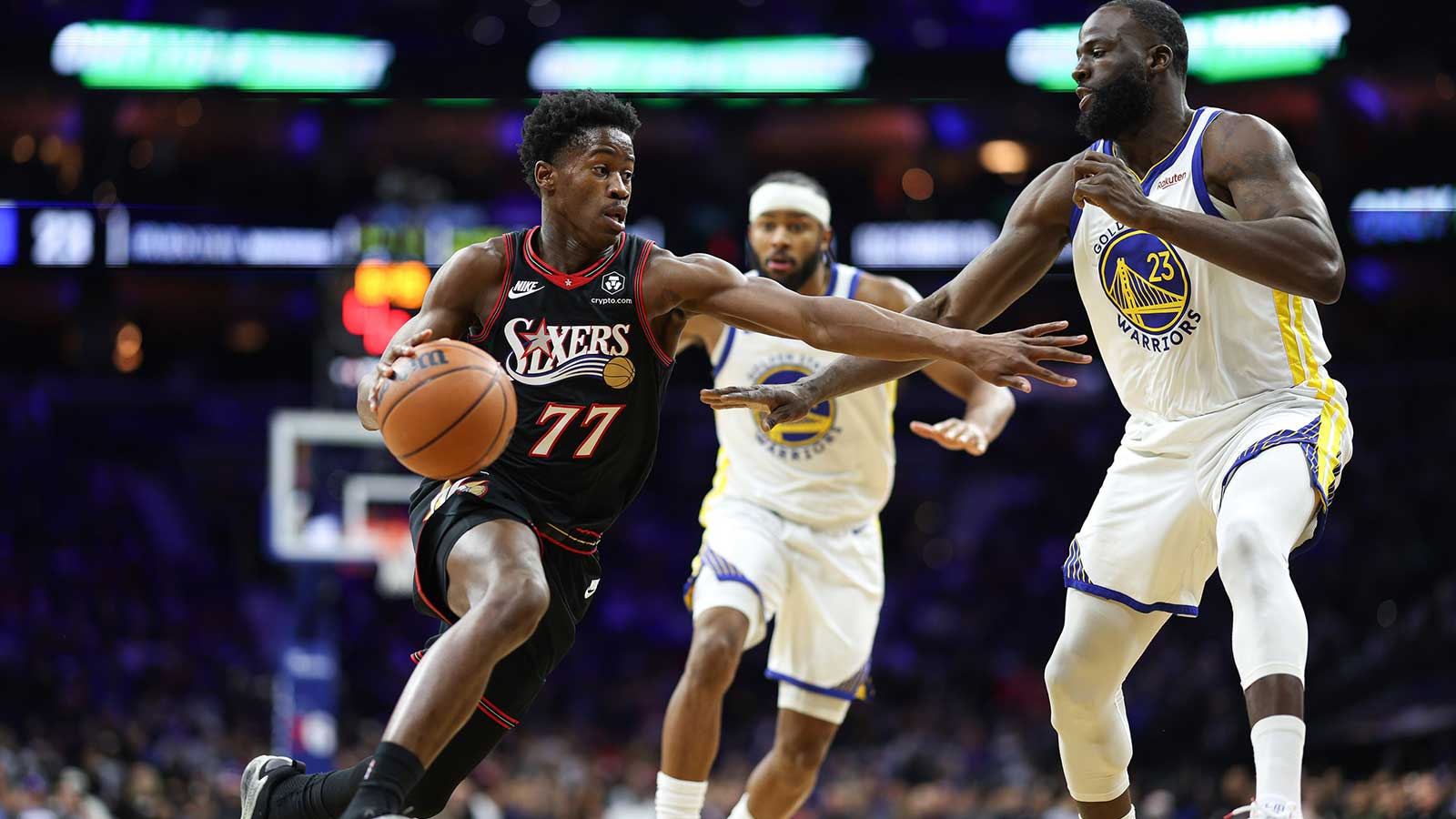 Philadelphia 76ers guard VJ Edgecombe (77) drives against Golden State Warriors forward Draymond Green (23) during the second quarter at Xfinity Mobile Arena.