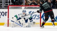 Vancouver Canucks goalie Kevin Lankinen (32) stops a shot by Seattle Kraken forward Eeli Tolvanen (20) during a shoot out at Climate Pledge Arena.