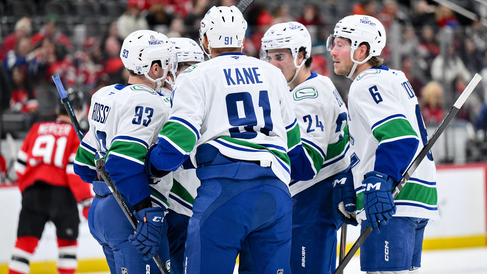 Vancouver Canucks defenseman Zeev Buium (24) celebrates with teammates after scoring a goal against the New Jersey Devils during the first period at Prudential Center.
